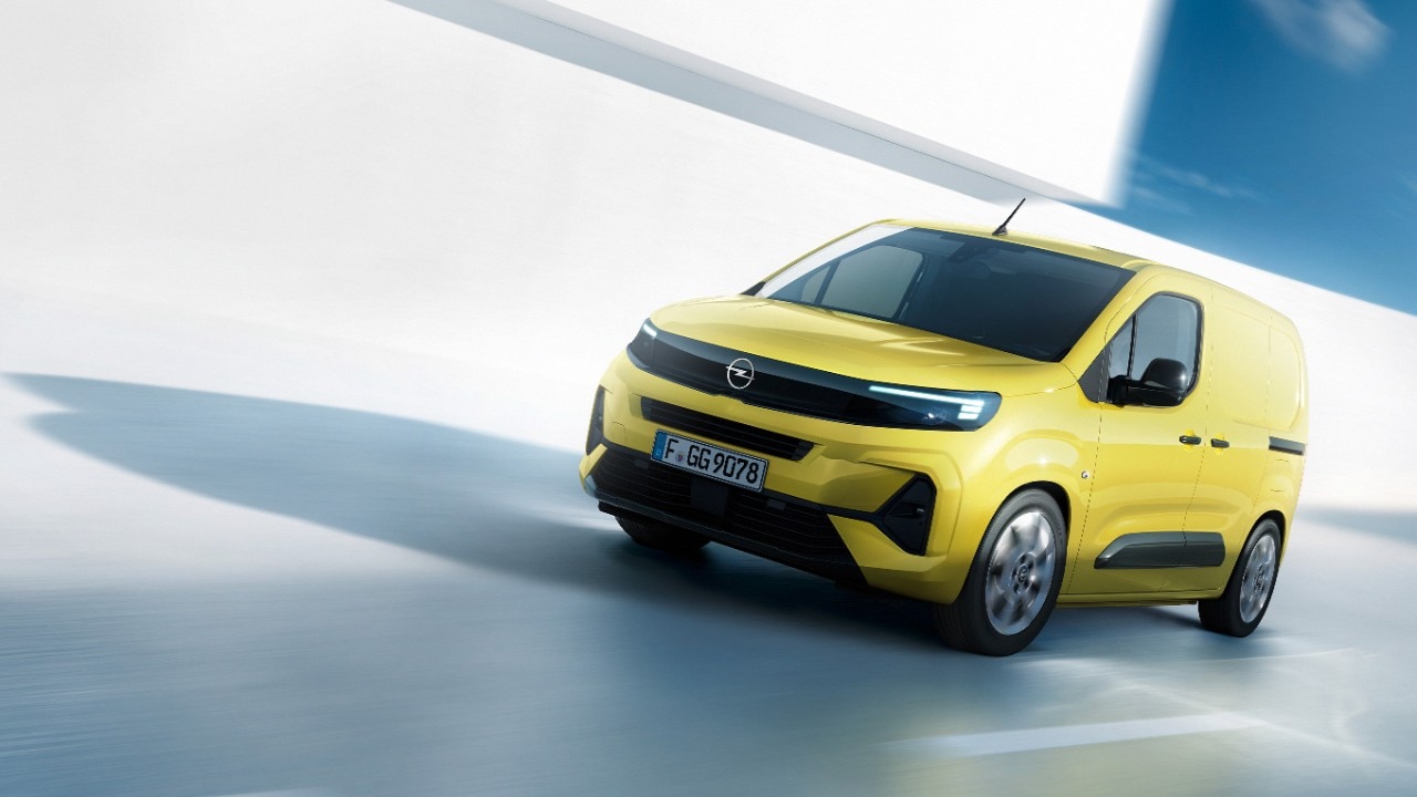 Zijaanzicht voorkant van een nieuwe gele Opel Combo Cargo in beweging